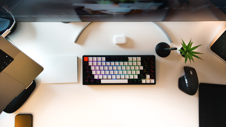 Top-down view of a mechanical keyboard on a desk in front of a monitor.