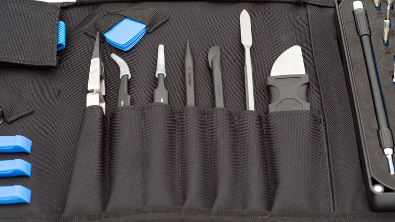 An iFixIt toolkit sitting in its holding case spread open on a table