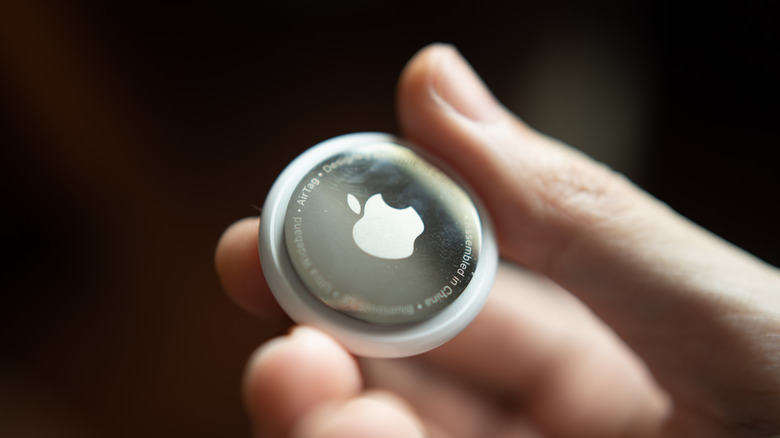 A person holding an AirTag