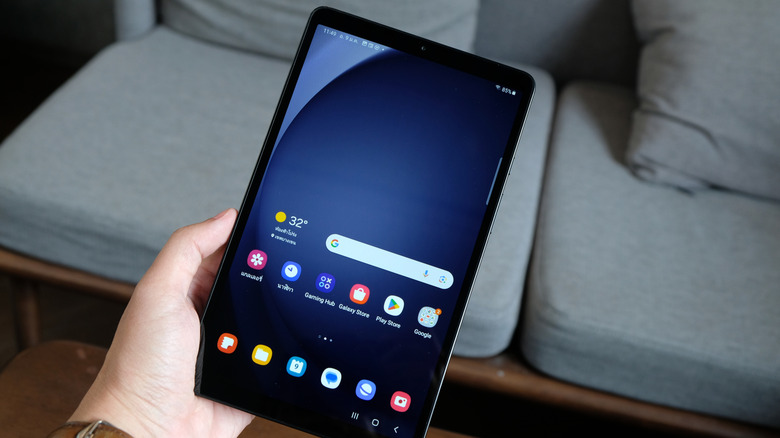 Someone holding a Samsung Tab A9 in a living room