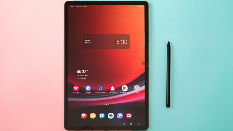 a Samsung Galaxy Tab S9+ next to a stylus on a green and pink table