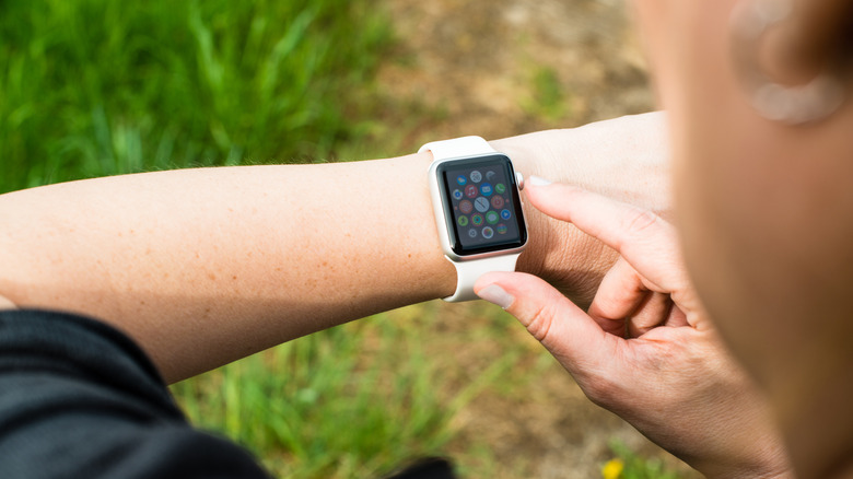 A person's hand touching the Digital Crown on an Apple Watch