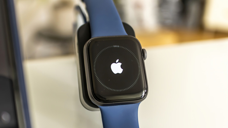 An Apple Watch with a blue wrist band showing the Apple logo
