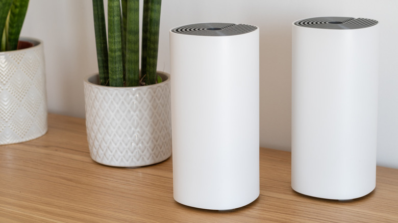 Mesh router nodes next to each other in a brightly lit room.