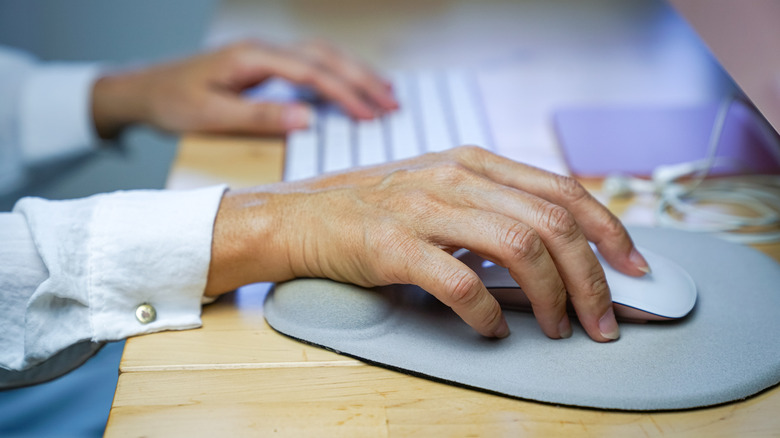 A woman using a Magic Keyboard and mouse