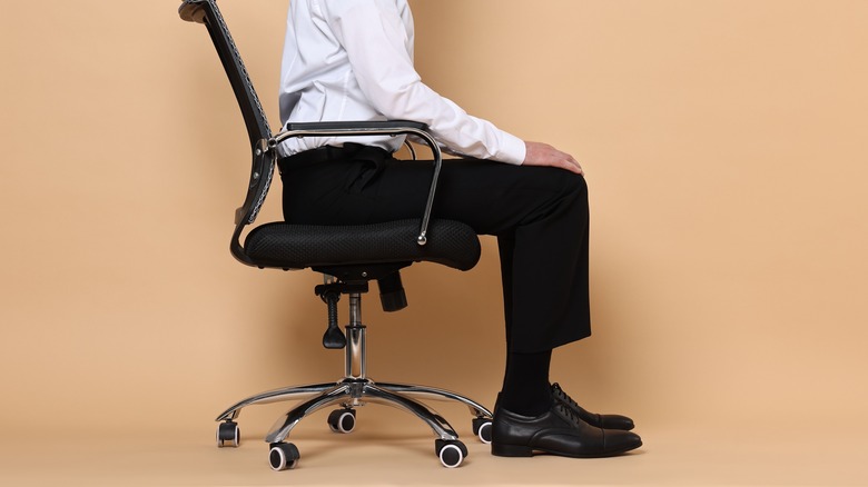 Man showing correct sitting posture on office chair