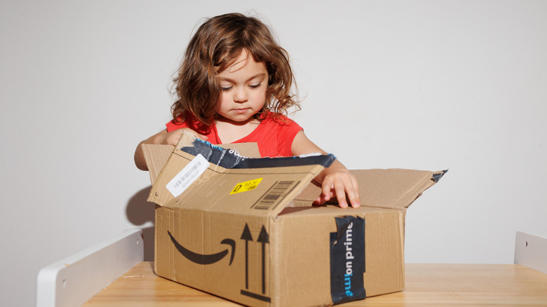 A child opening an Amazon Prime package.