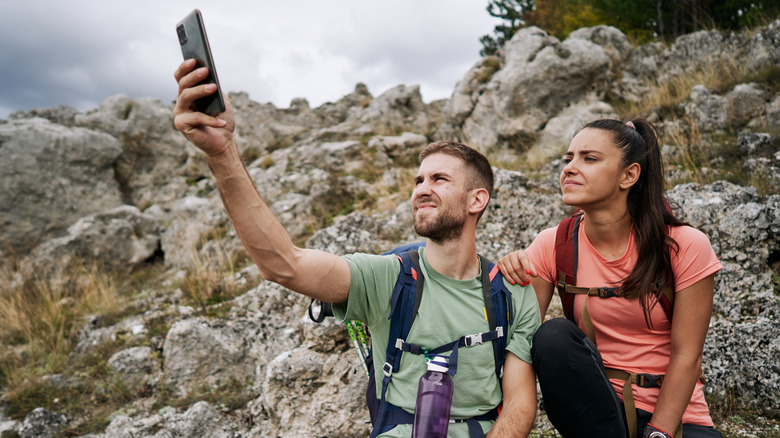 Couple looks for phone signal outdoors
