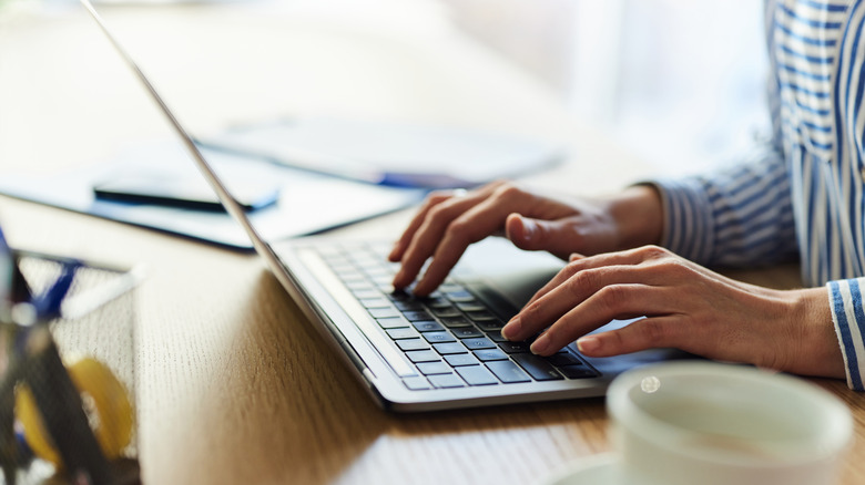 A person typing on a laptop