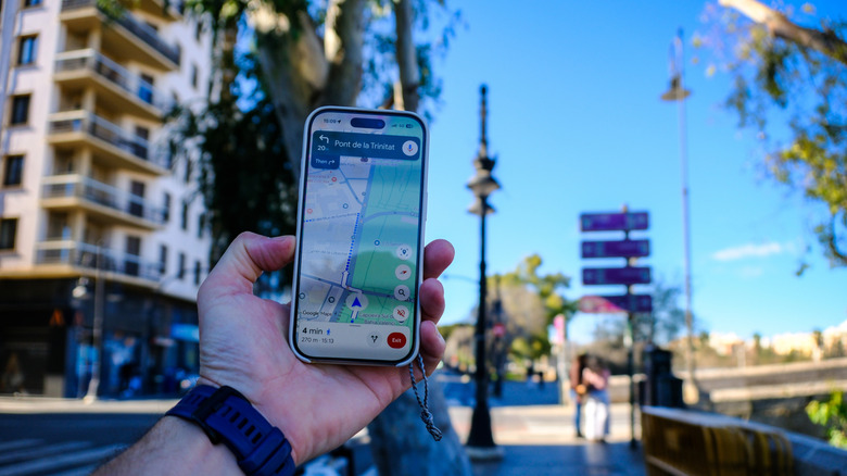 A smartphone in a person's hand showing Google Maps navigation