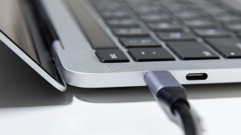 Close up of a USB Type-C cable plugged into the port on a laptop.