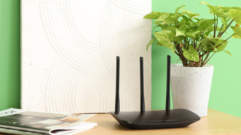 Home network router resting on shelf with decor