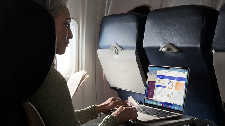 Woman using MacBook Air on airplane