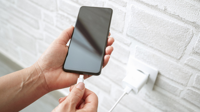 Plugging a USB-C cable into a smartphone.