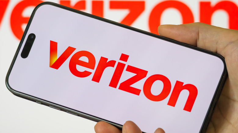 a hand is holding a Verizon cell phone with the logo on it