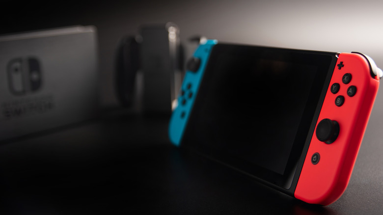 A Nintendo Switch with accessories on a black background
