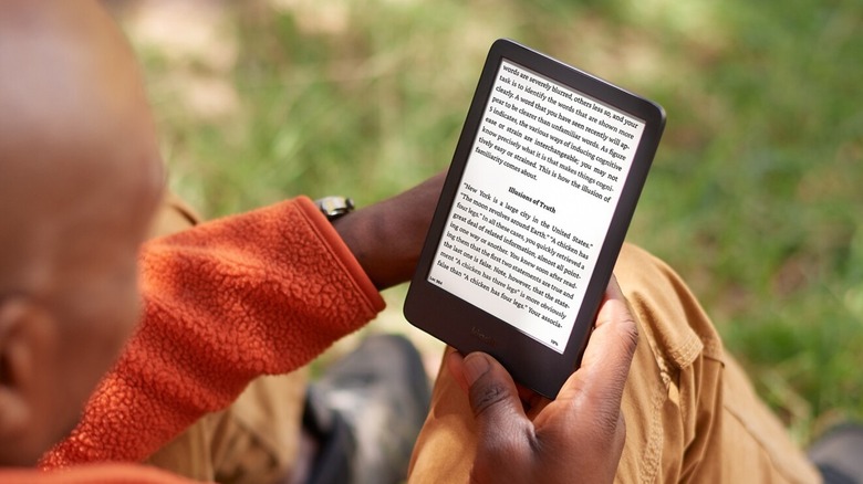 Person reading a Kindle outdoors
