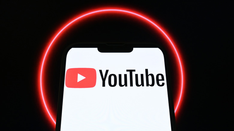 The YouTube app and logo displayed on a phone with a red halo behind.