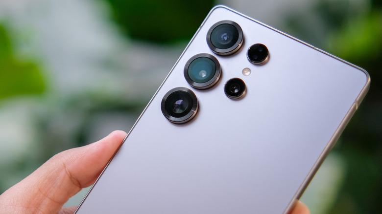 A hand holding a Samsung Galaxy S25 phone.