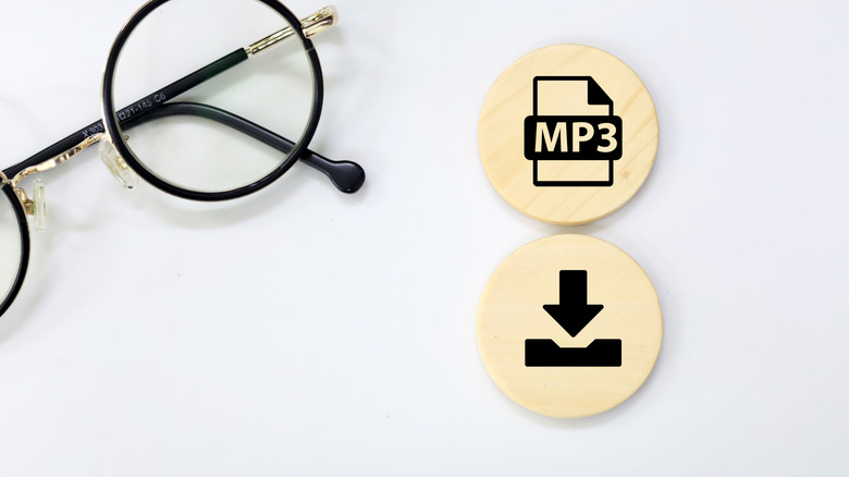 MP3 and download icons on wooden circles next to a pair of eyeglasses