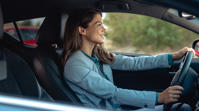 a happy businesswoman driving in the car