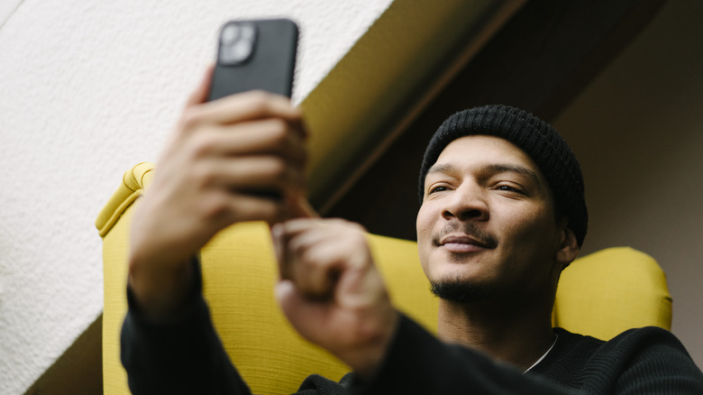 A person using an iPhone to take a selfie photo.