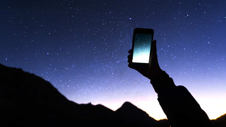 Holding a phone up to photograph the night sky