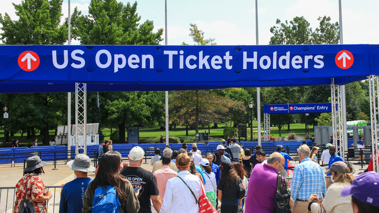 A crowd gathers outside the U.S. Open ticket holder gates, several people are waiting to be let inside