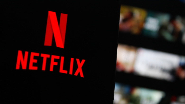 Netflix logo in foreground with app interface in the background out of focus