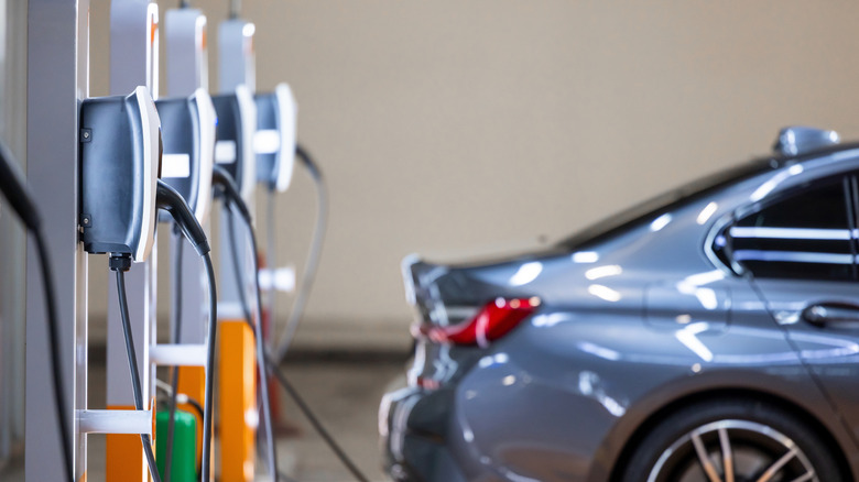 An electric car backed up to a row of chargers
