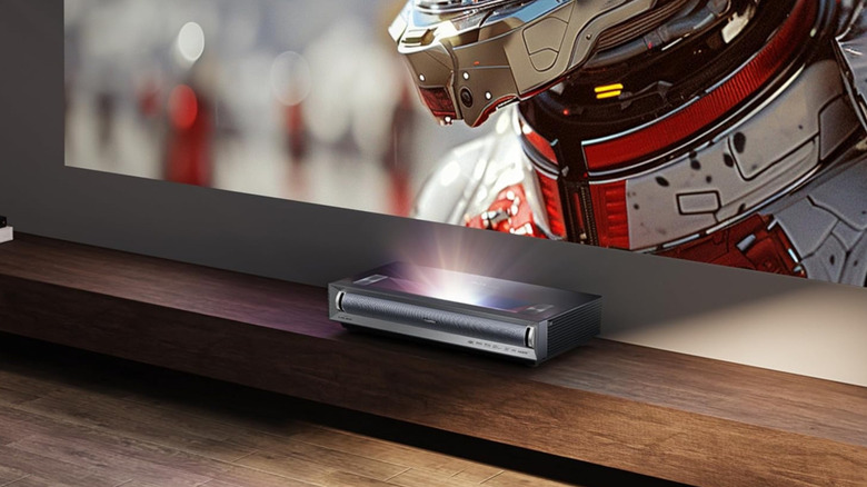 The Hisense PX3-PRO projecting an image on a wall from a shelf.