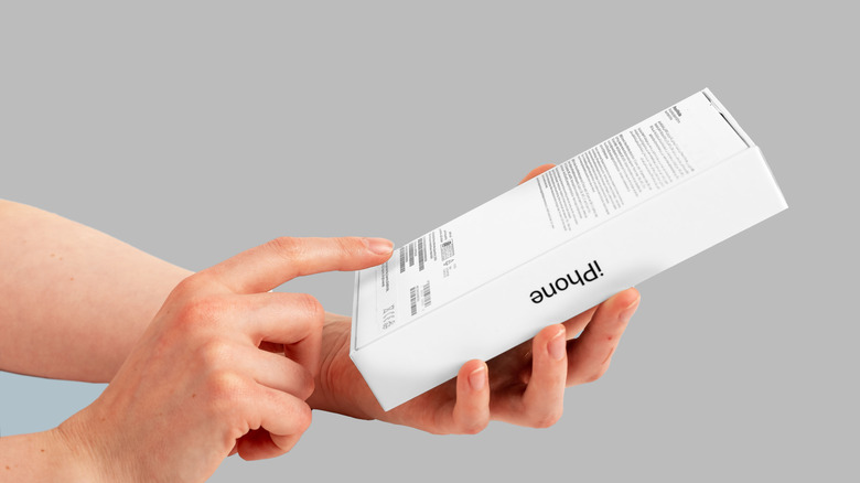 A person checking the serial number on an iPhone box