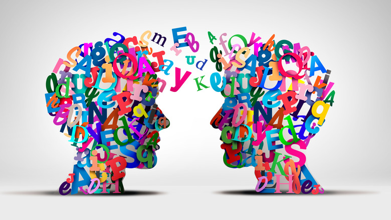 an artistic image representing language learning of two heads made up of letters