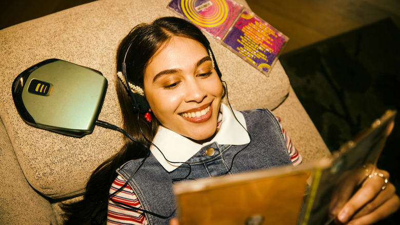 concept of nostalgia, woman listening to CD player in oldschool headphones