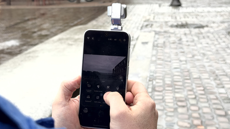 Looking over someone's shoulder at the Honor Robot Phone with gimbal extended while its filming