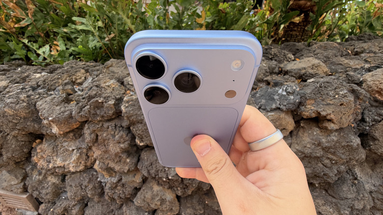 iPhone 18 Pro in Glacier color being held in front of rocks