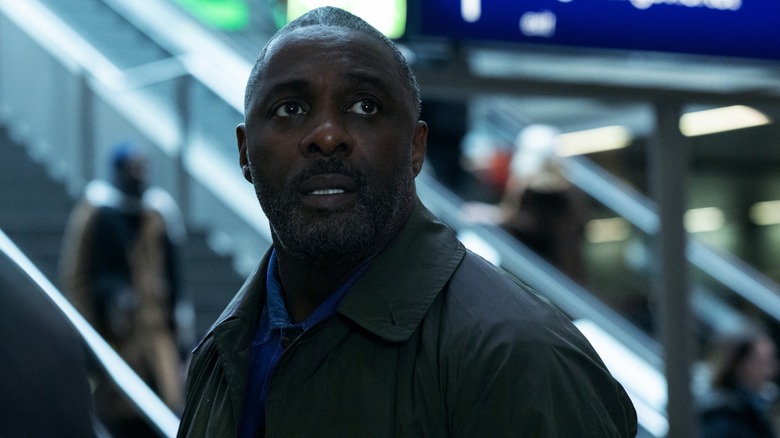 An official Apple TV photo from Season 1, Episode 1 of Idris Elba's "Hijack," the image centers on Elba as he stares at something off camera while inside a train station