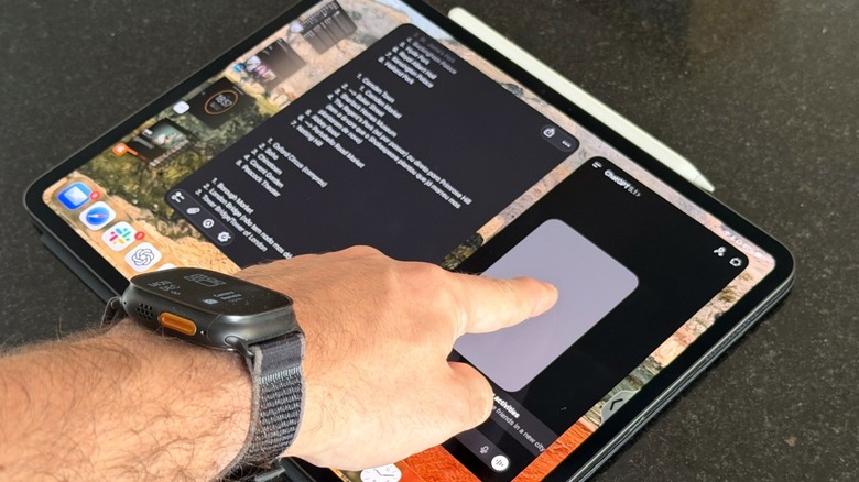 A hand touching an iPad display with Stage Manager on
