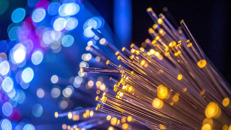 Fiber-optic cables with blue and orange light coming out of the tips of the wire