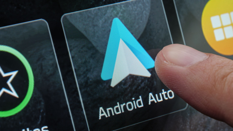 Close up of finger touching Android Auto on a display.