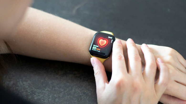 Woman measuring heart rate with Apple Watch