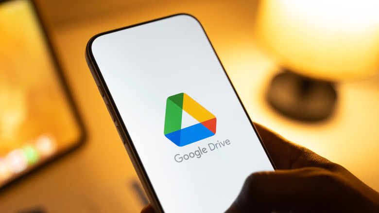 Hand holding phone showing Google Drive logo