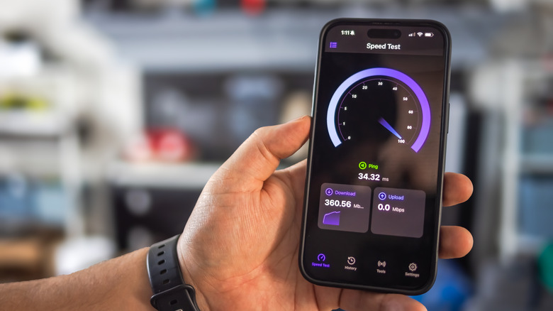 Hand holding phone running internet speed test