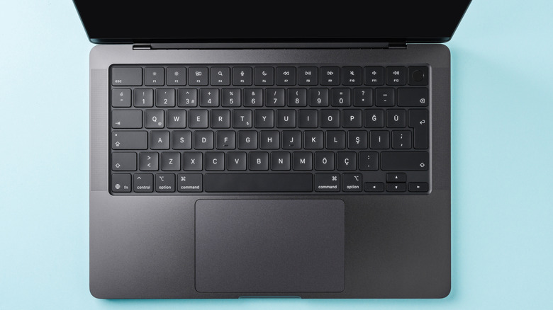 A MacBook's keyboard in view, with the black screen