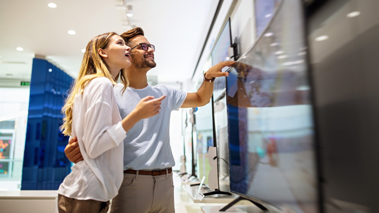 A couple showing for a new TV at an electronics store.