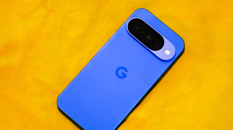 A Google Pixel 10 smartphone against a yellow bckground