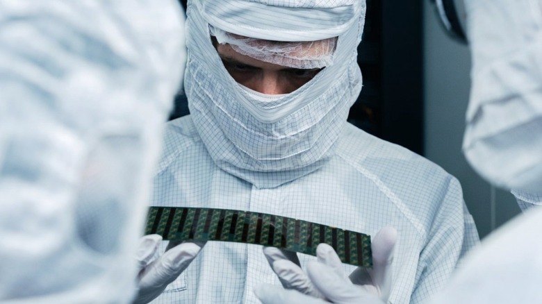 A man holding a NAND-flash memory in a factory