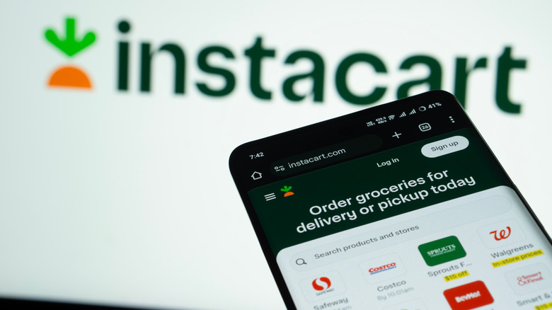 The Instacart app on a phone and the Instacart logo in the background.