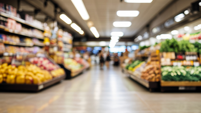 A blurred view of a grocery store's prouduce section.