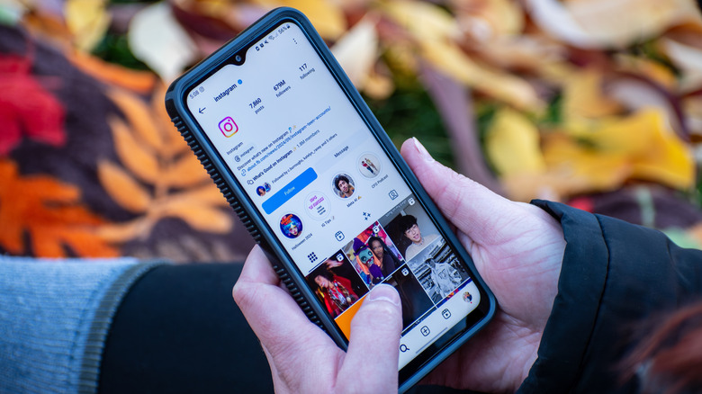 Someone holding their phone with Instagram visible on the screen.